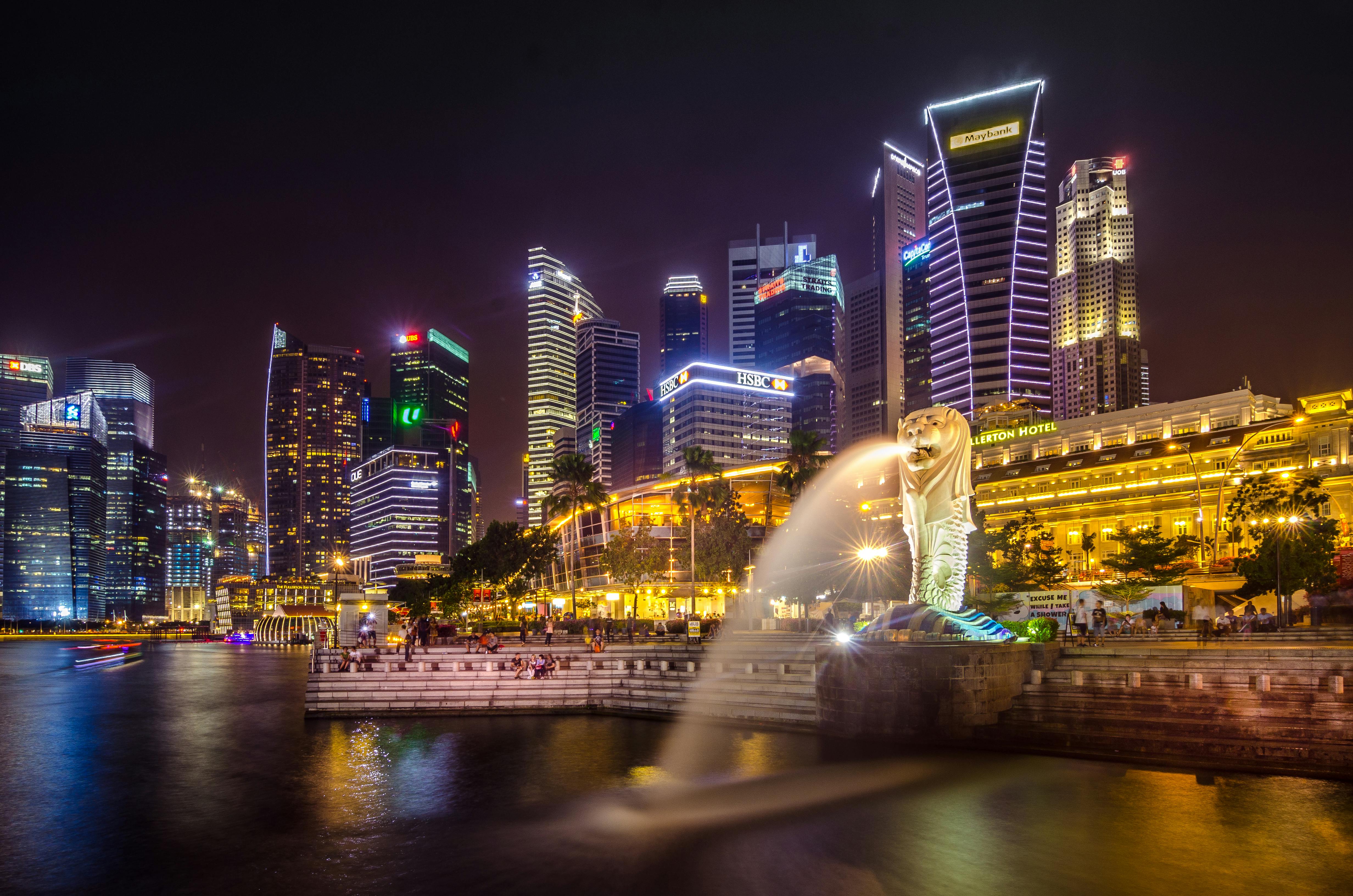 Singapore skyline at night with the Merlion and Marina Bay.